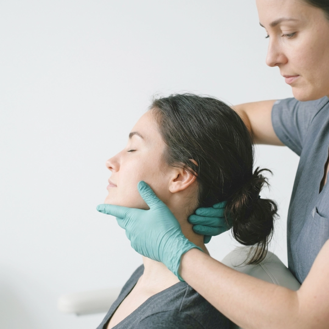 Practitioner performing gentle neck and jaw adjustment on relaxed patient