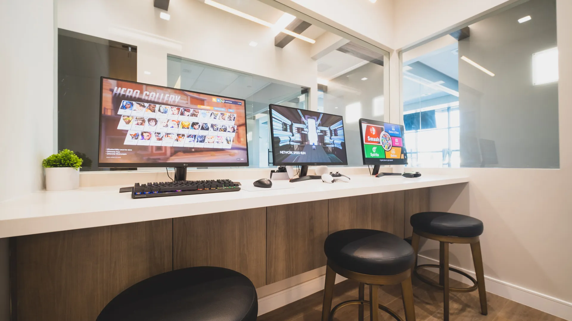 Interactive media station at Aviara Centers with gaming monitors, counter seating, and glass partitions