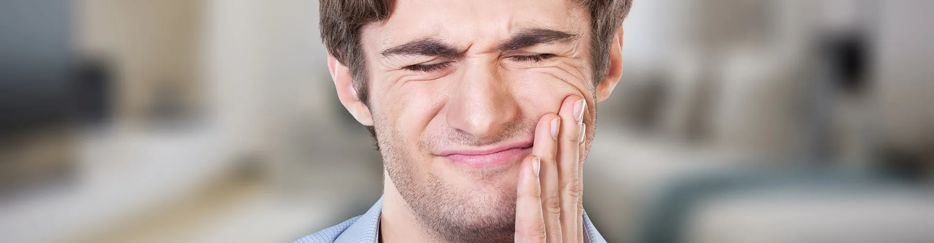 man-holding-jaw-in-pain