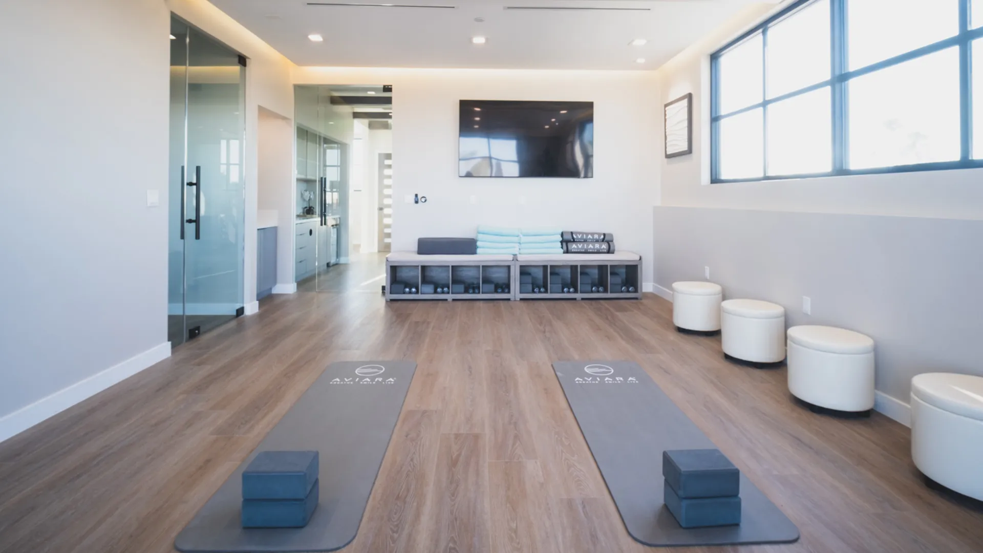 Movement and therapy studio at Aviara Centers with yoga mats, blocks, bench seating, and glass-walled entry