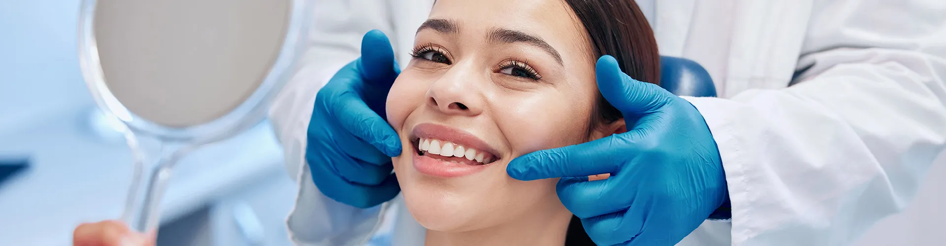 gloved hands pointing to woman's smile