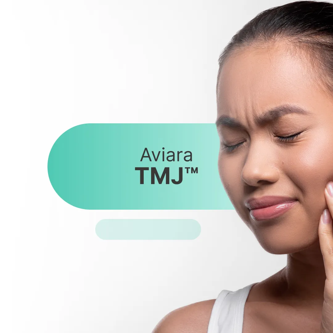 Woman experiencing TMJ pain, holding her jaw.