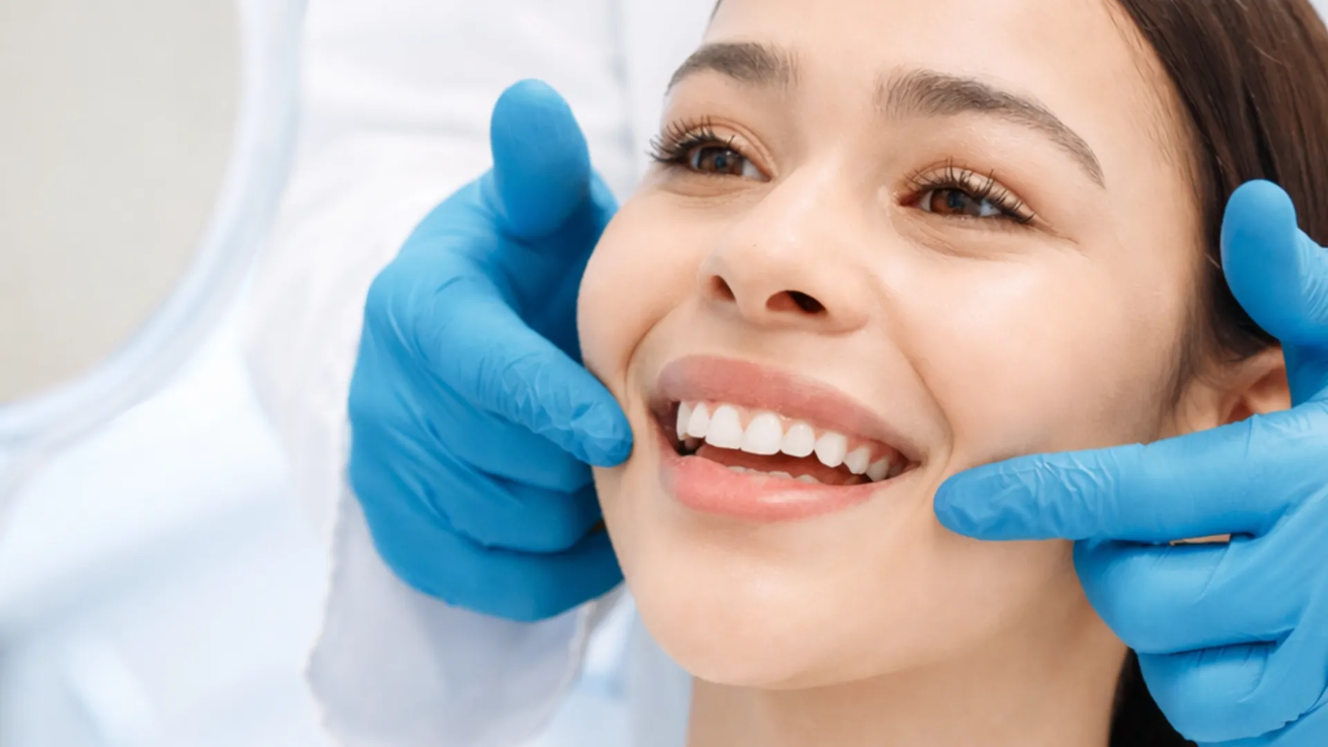 A close-up of a smiling patient’s teeth while seated in a dental chair during a clinic visit.