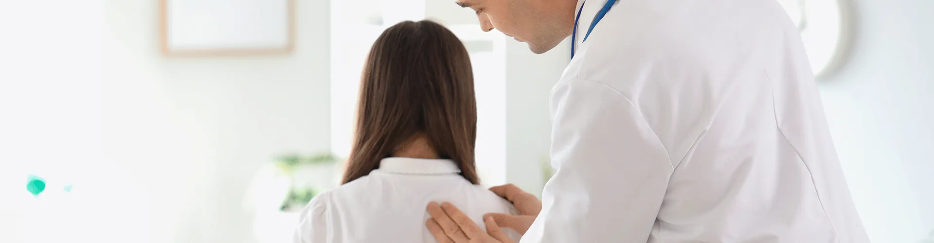 dentist pressing on female's back between her shoulders