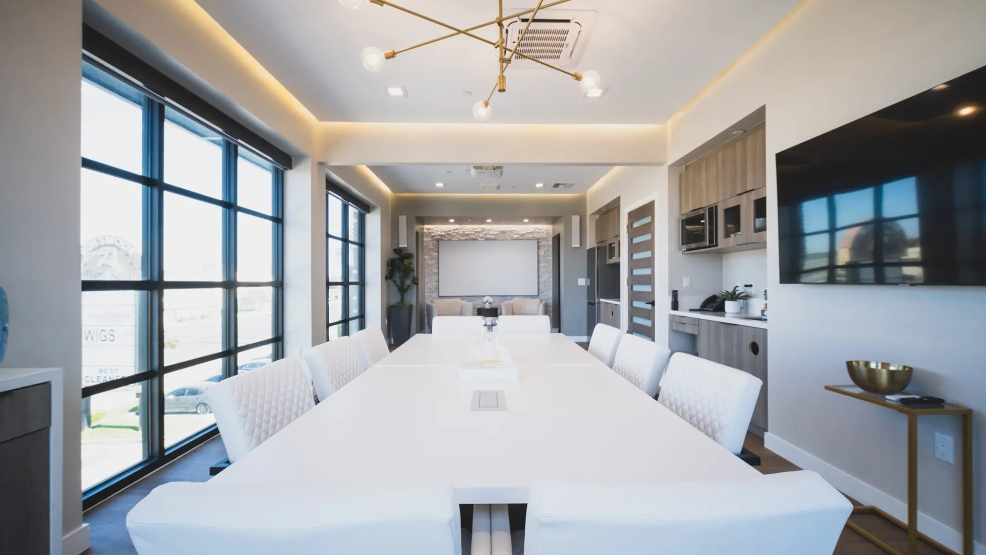 Conference room at Aviara Centers with long white meeting table, upholstered chairs, Aviara feature wall, and presentation screen
