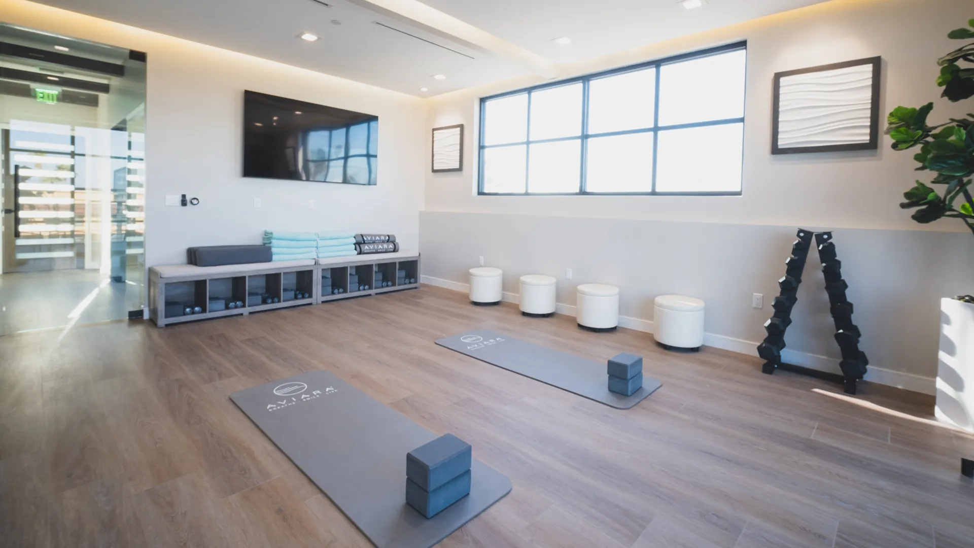 Wellness room at Aviara Centers with yoga mats, towels, free weights, and large windows for movement and therapy sessions
