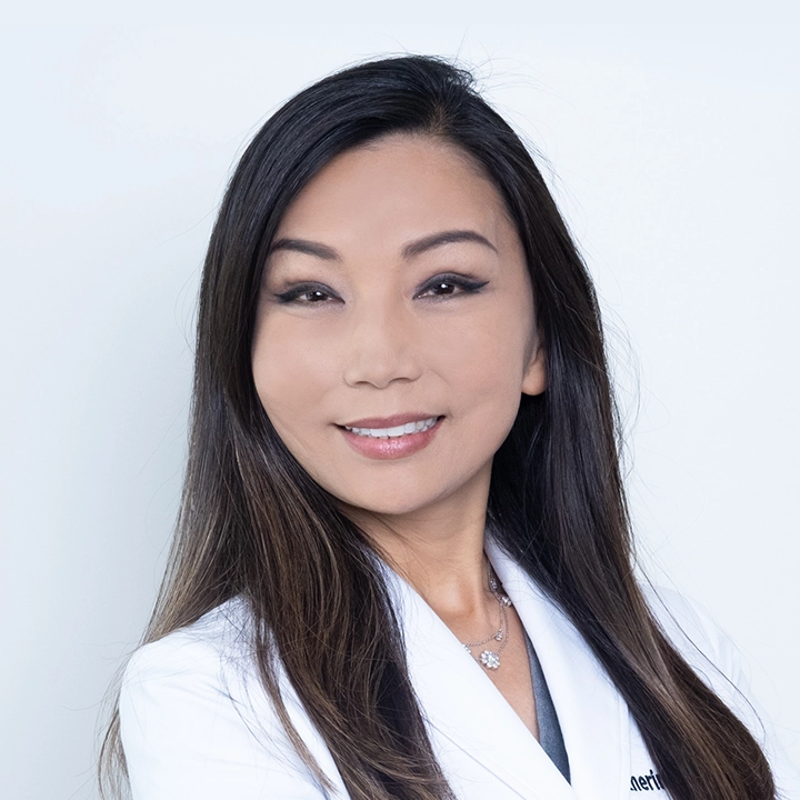 Professional photograph of Dr. Katherine Ahn-Wallace in studio and lab coat