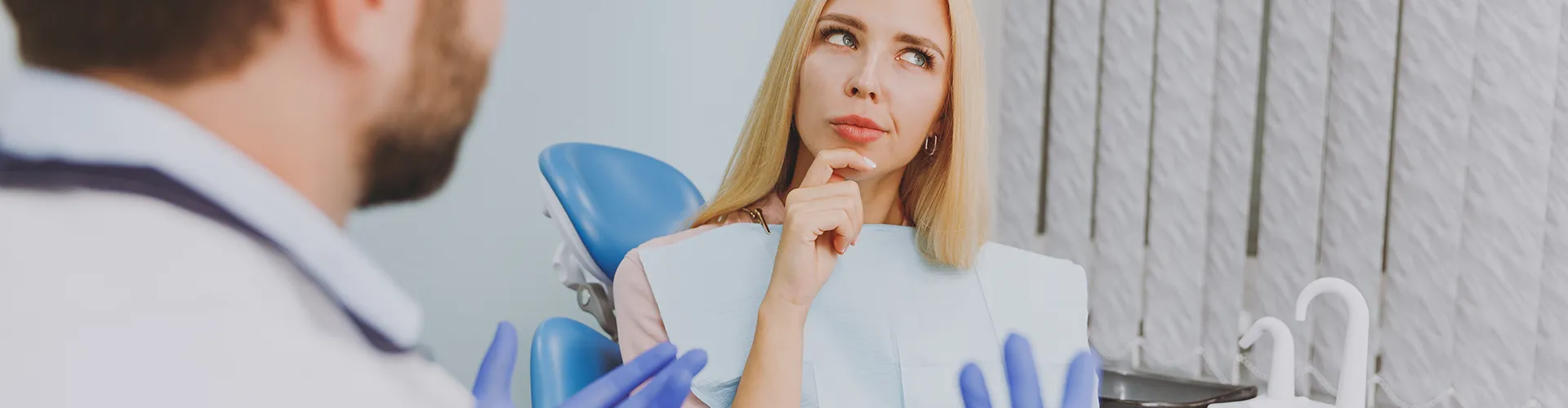 dentist talking to woman holding her chin in thought