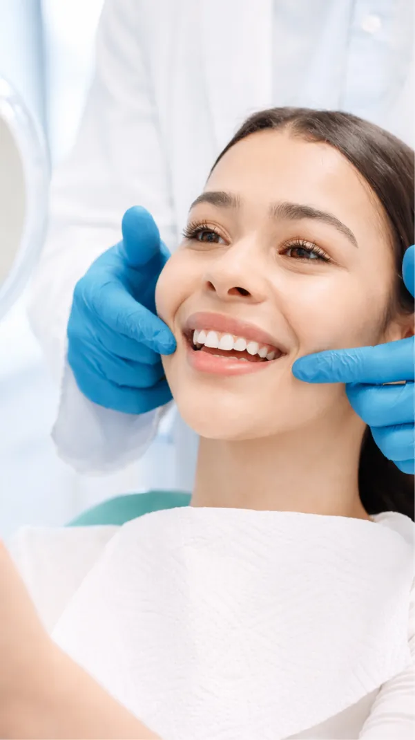 A close-up of a smiling patient’s teeth while seated in a dental chair during a clinic visit.