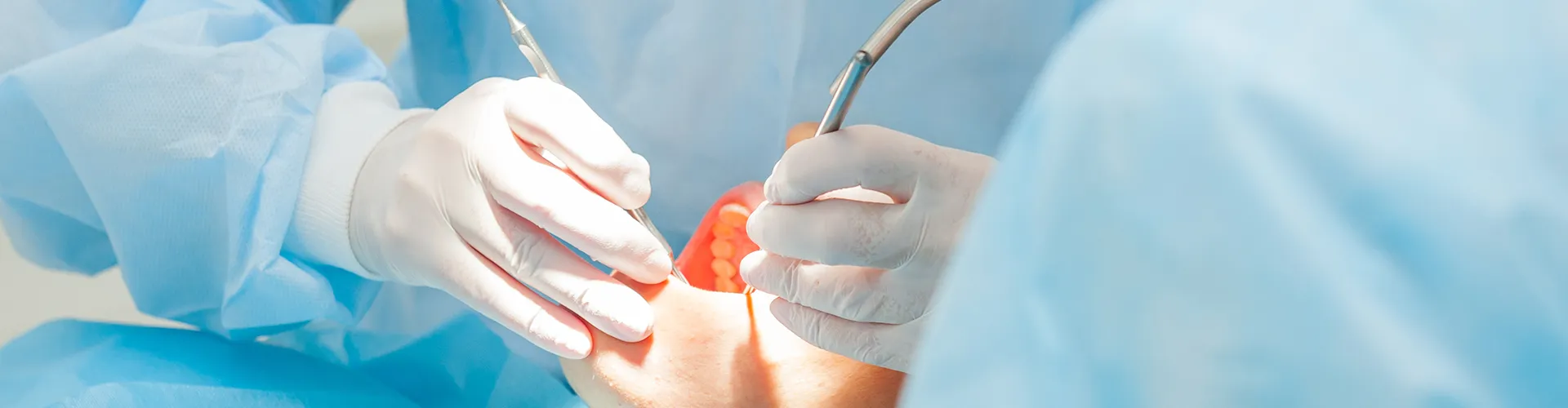 dentist using dental tools on reclining patient's open mouth