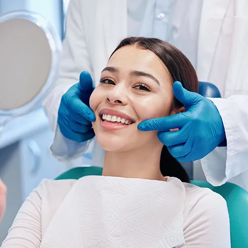 gloved hands pointing to woman's smile
